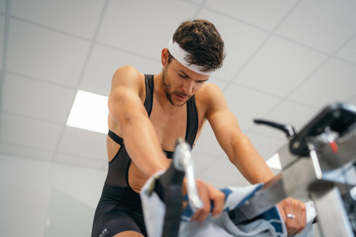 Triathlet mit Atemmaske bei der Leistungsdiagnostik auf dem Ergometer